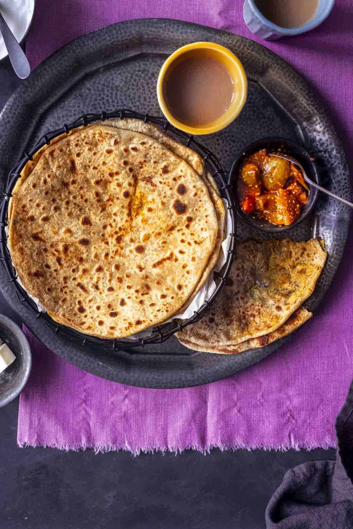 few aloo methi parathas served with pickle,butter and tea.