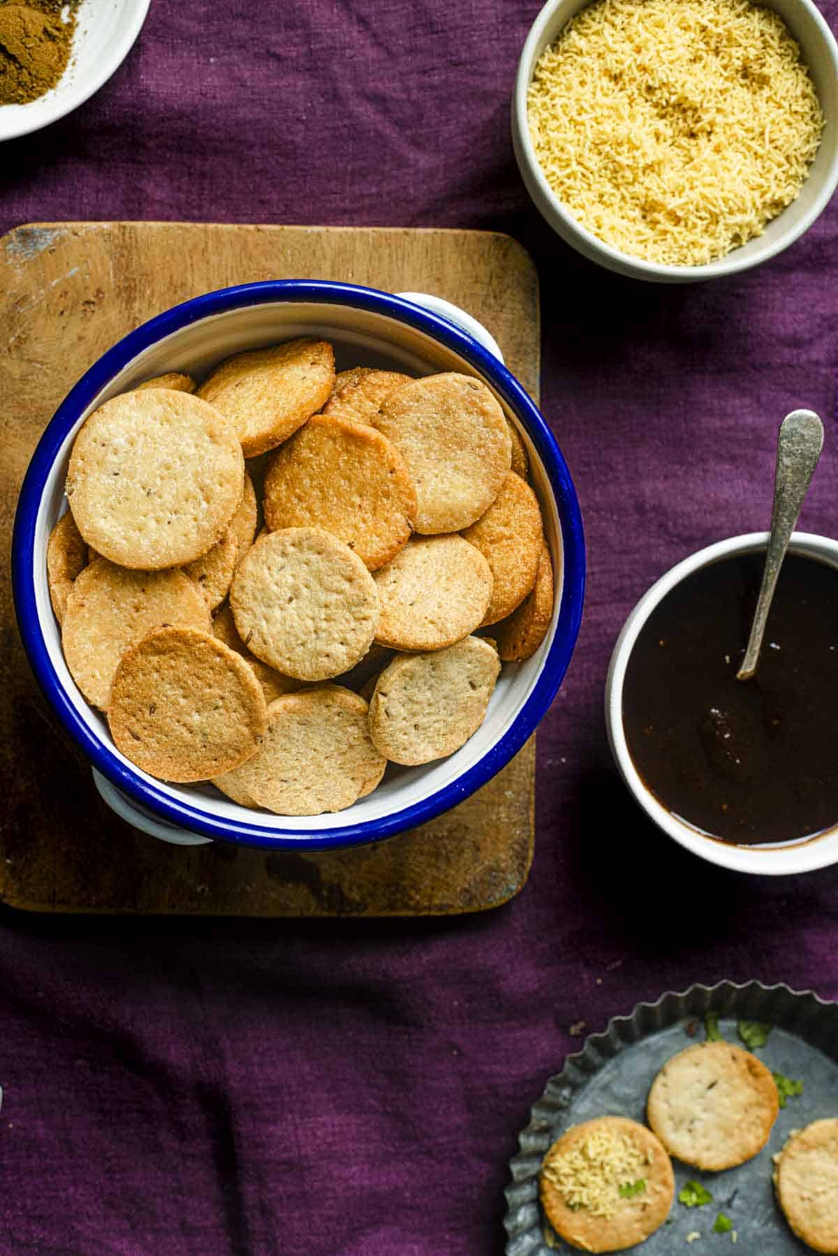 papdi for chaat, sev, dates tamarind chutney on a burple background.