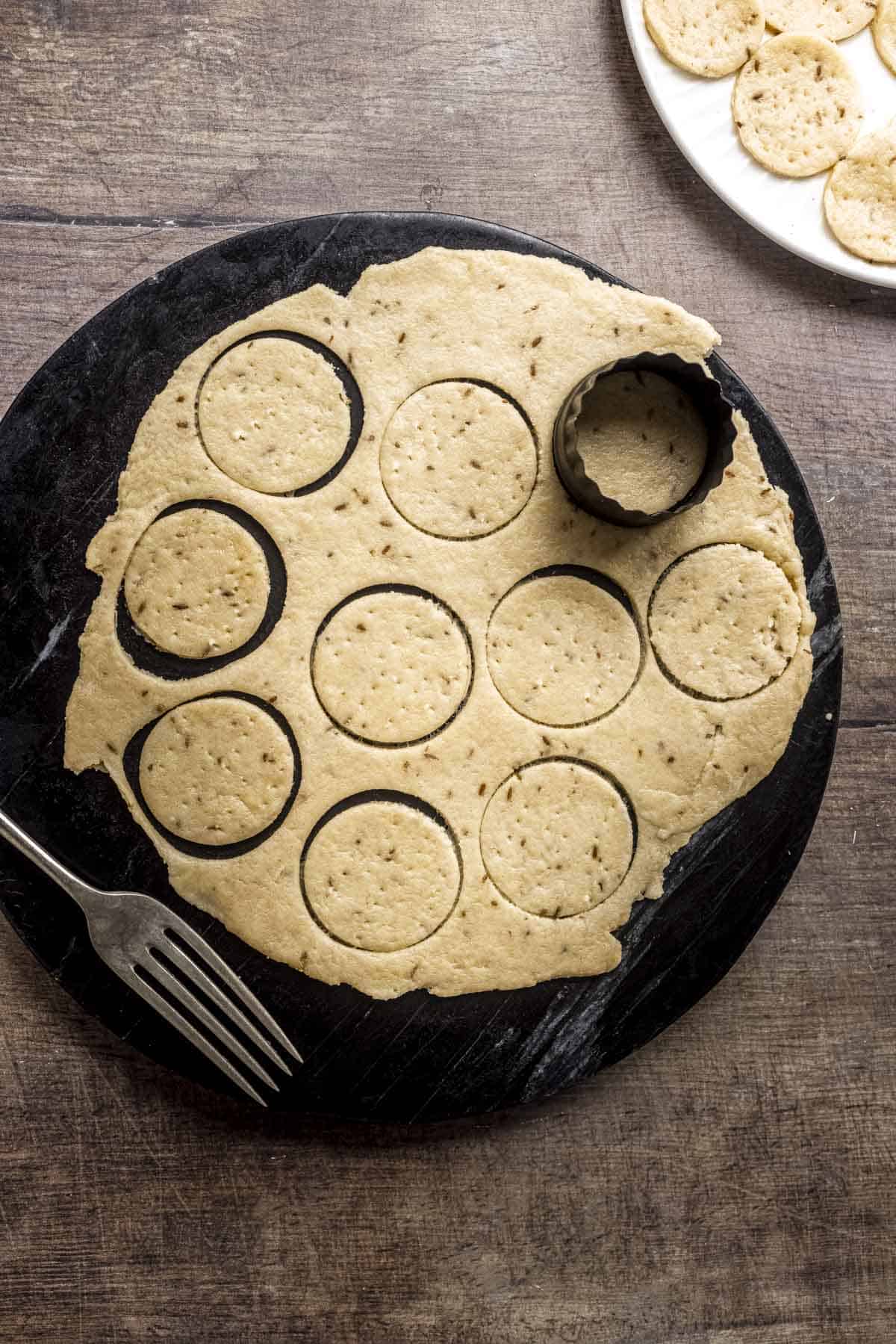 small circles cut with a cookie cutter and dock with fork.