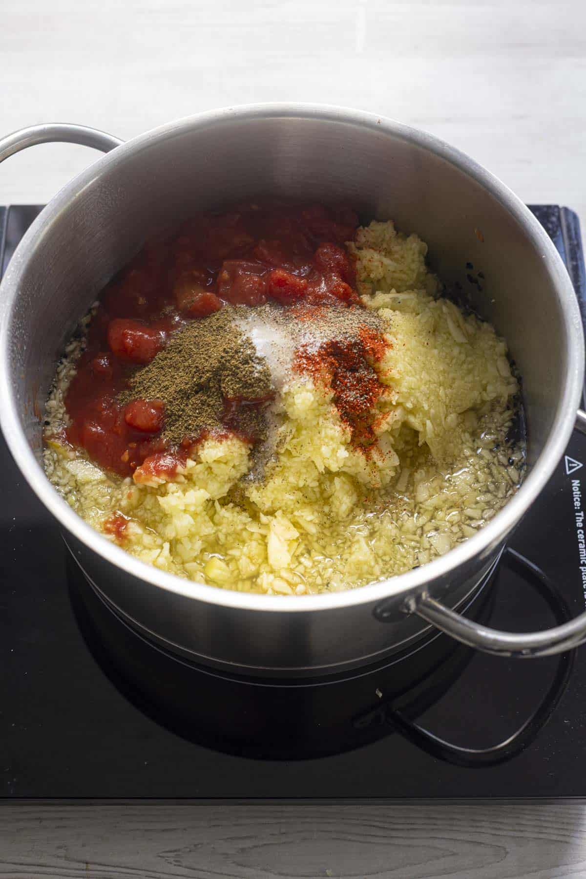 apples, tomatoes, spices and sugar in the stainless steel pan.