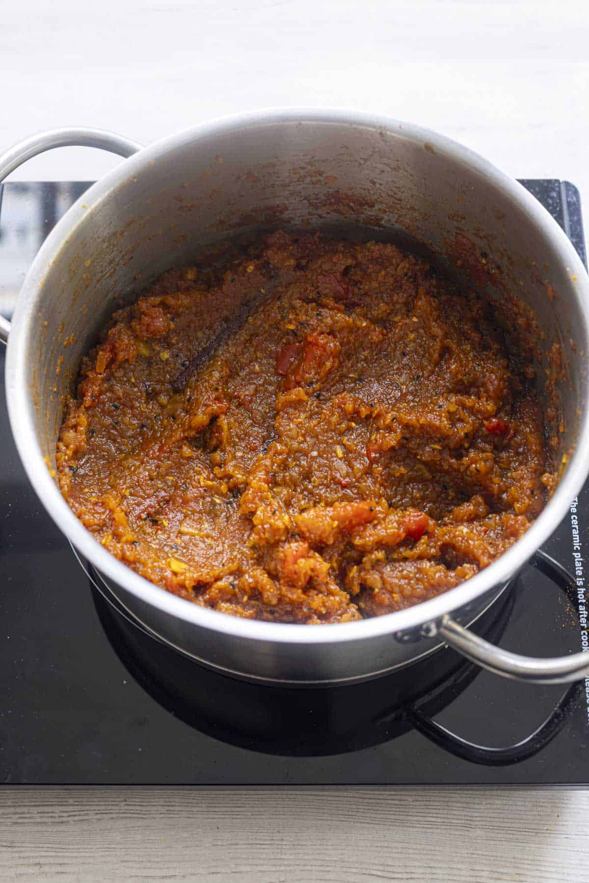 cooked apple tomato chutney in the stainless steel pan.