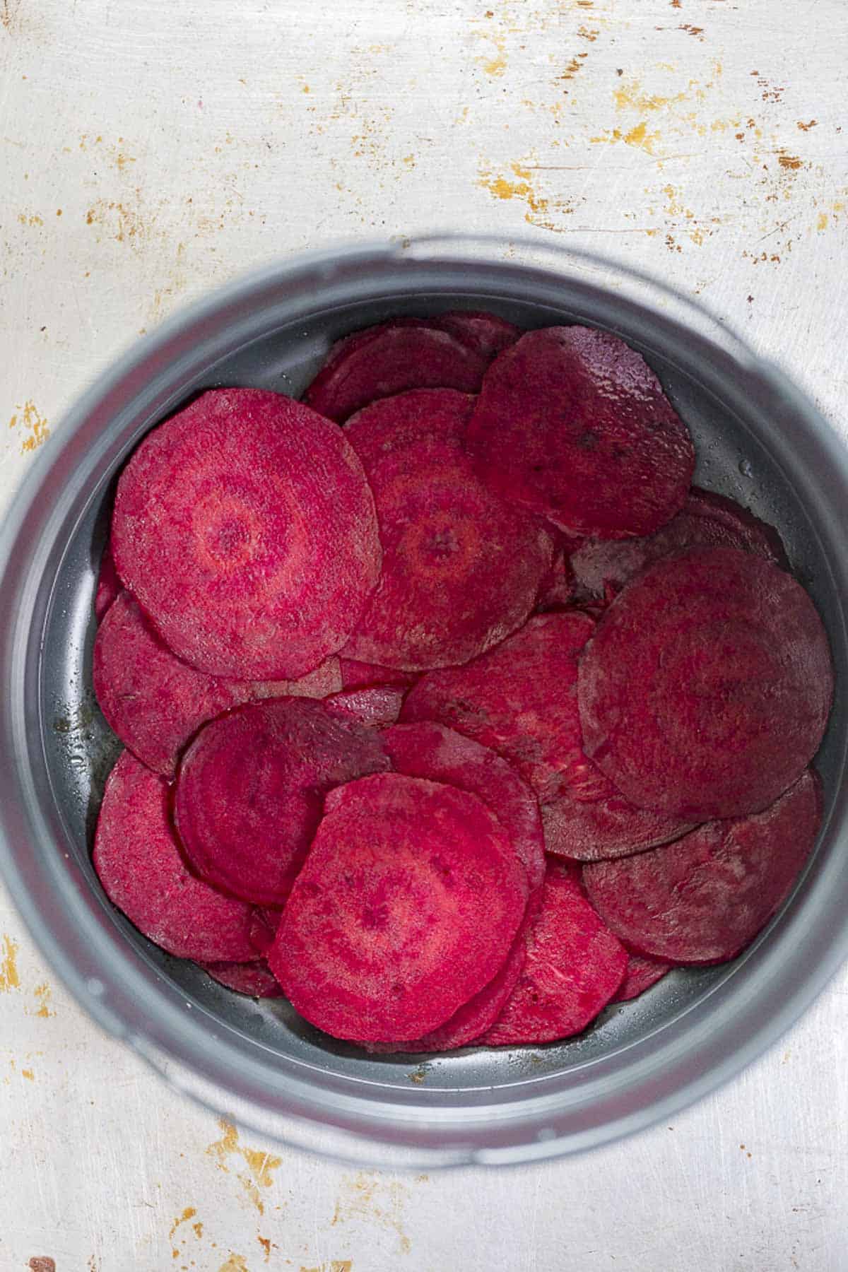 arrange seasoned red beet slices in air fryer basket.