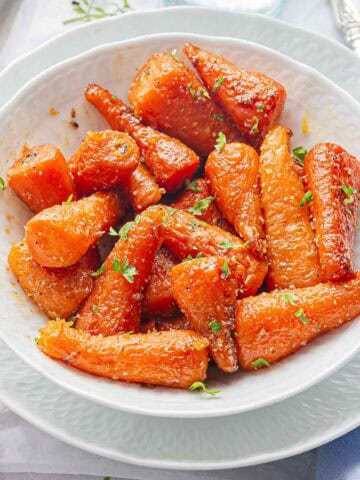 a white bowl full of instant pot glazed carrots.