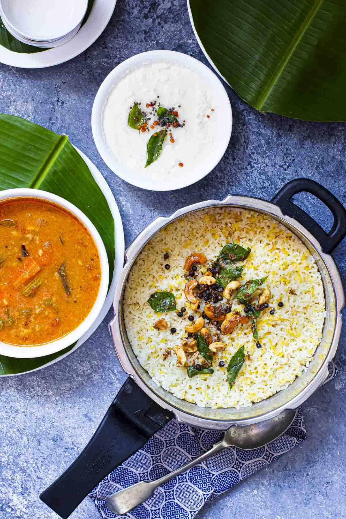 ven pongal served in a pressure cooker pan, sambar and coconut chutney