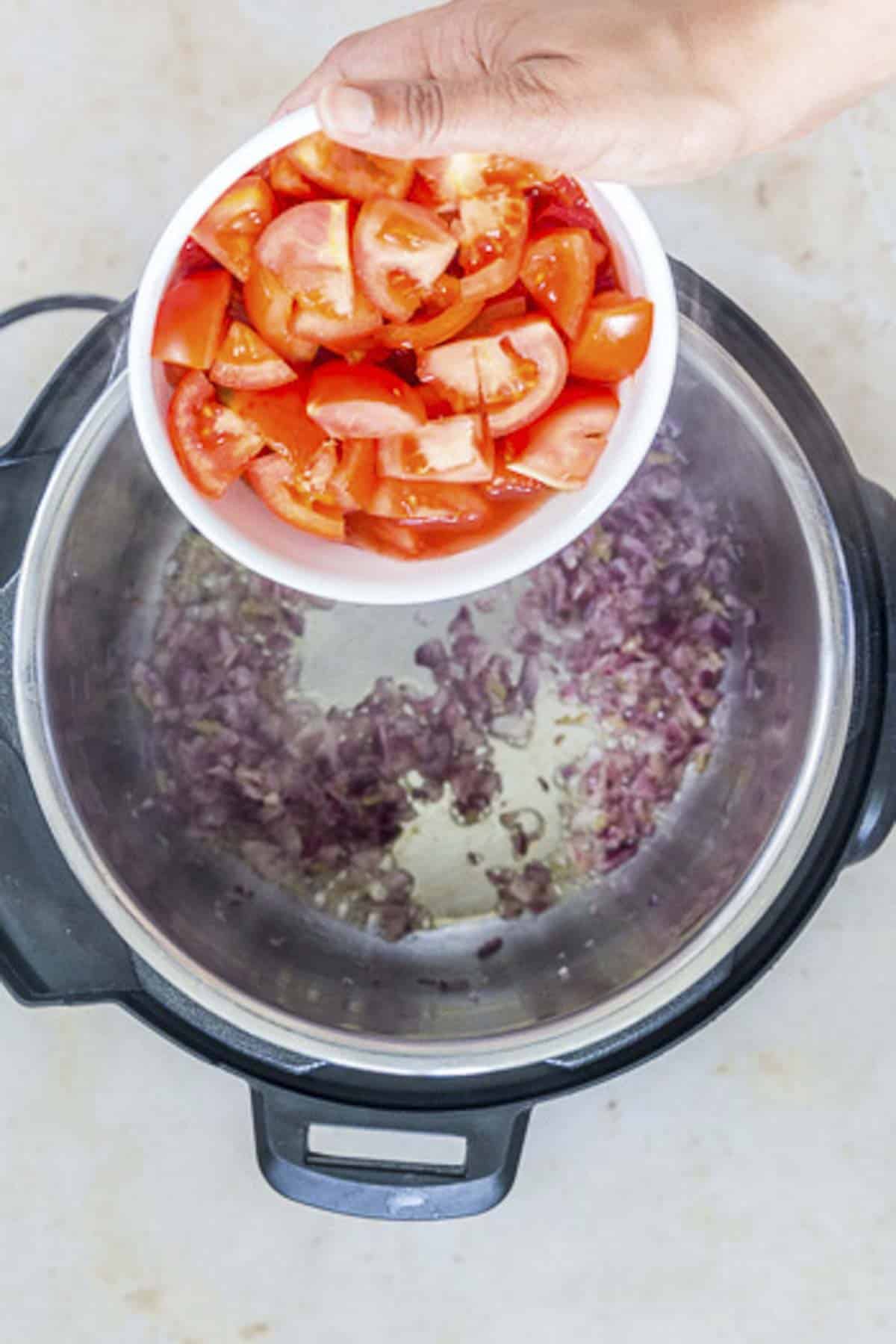adding tomatoes to the instant pot.