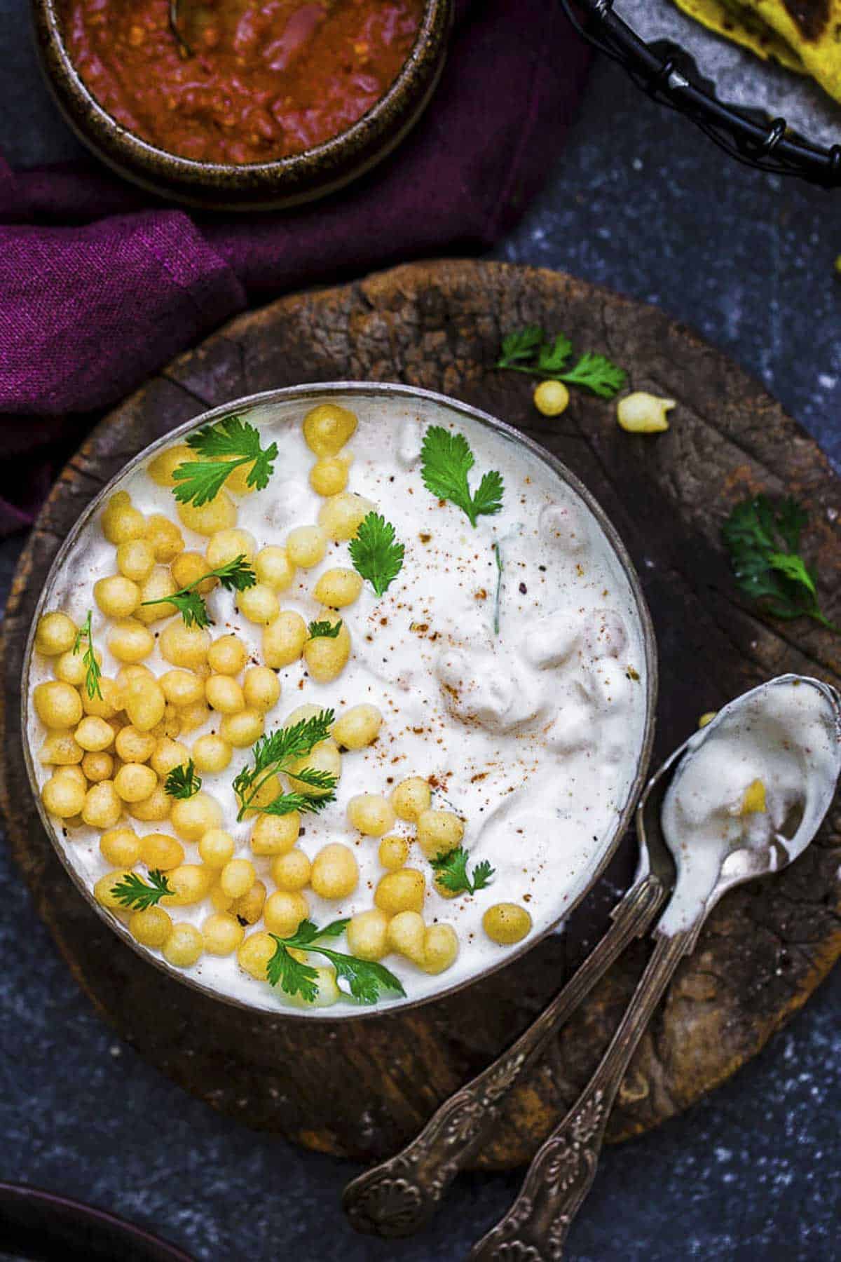 Indian boondi raita served in a bowl with crunchy boondi, fresh coriander.