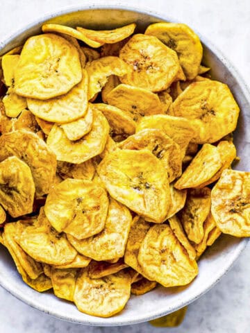a white bowl of air fryer plantain chips.