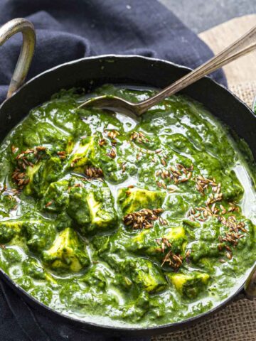 creamy palak paneer served in a kadai bowl
