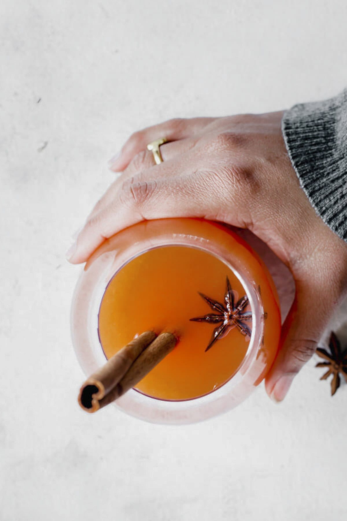 apple cider in a glass served with cinnamon stick and star anise.