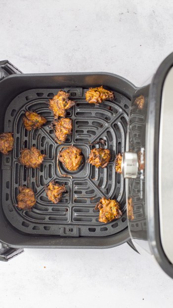 air fried onion bhajis in air fryer basket.