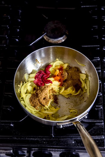 tomato puree,spices and onion in a sauce pan.