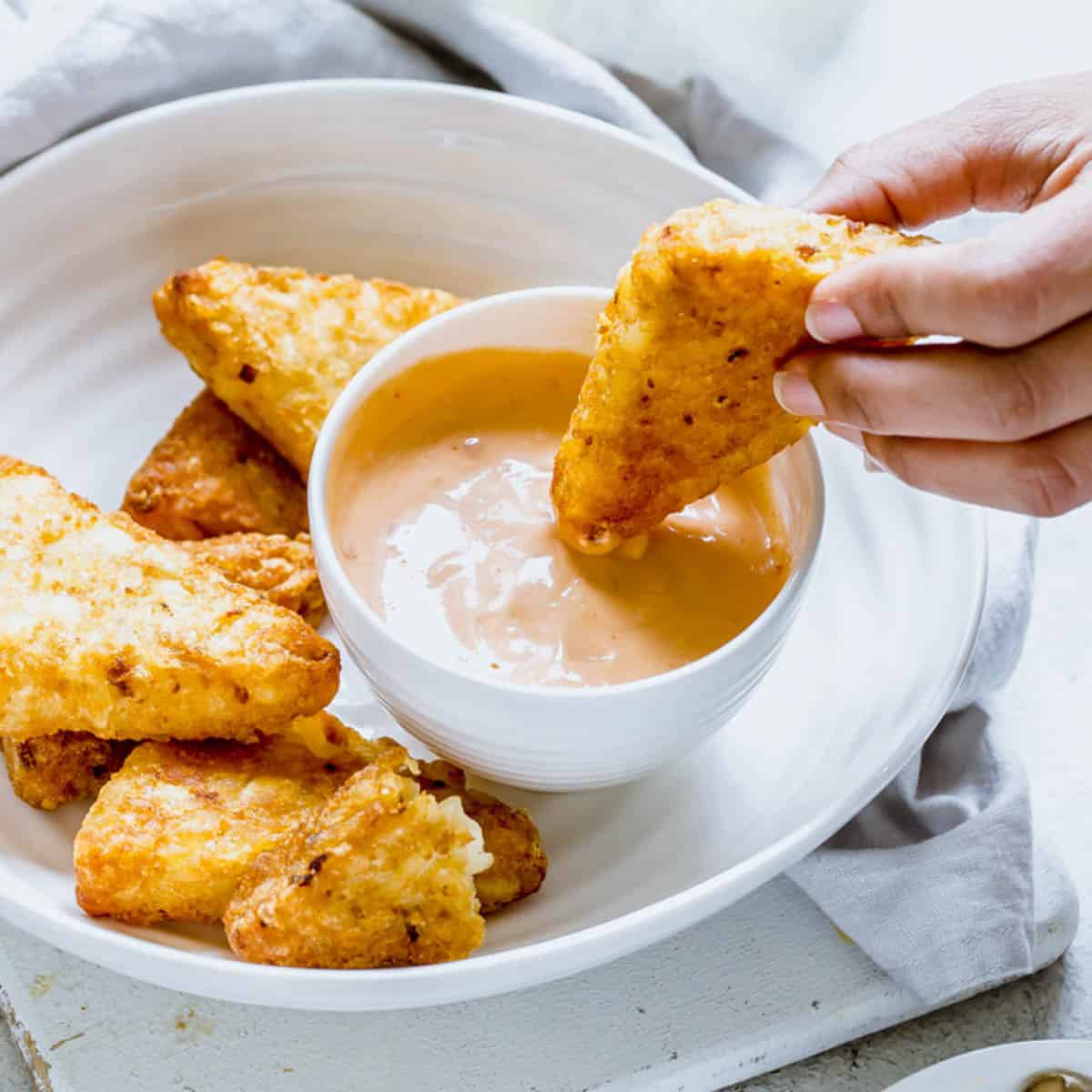 hash browns dipped in mayonnaise based sauce.