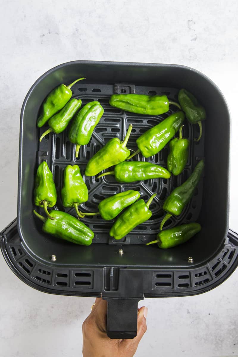 shishito peppers in air fryer basket.