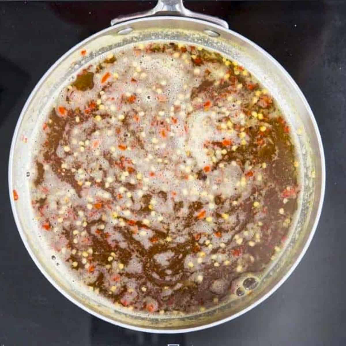 pineapple sweet chilli sauce boiling in sauce pan.