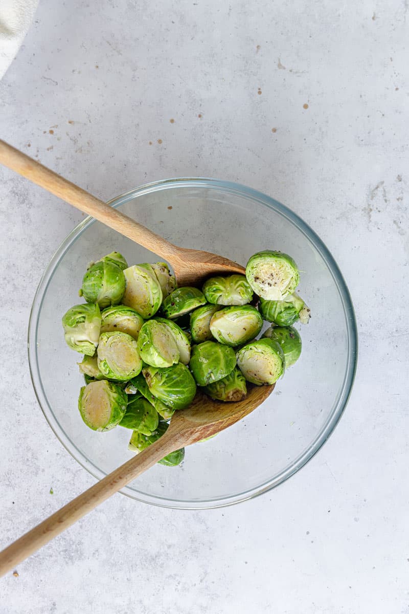 Brussels sprouts with seasoning in a bowl.