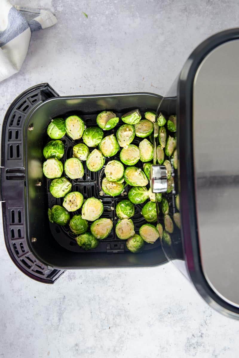 Garlic Seasoned brussels sprouts in the air fryer basket.