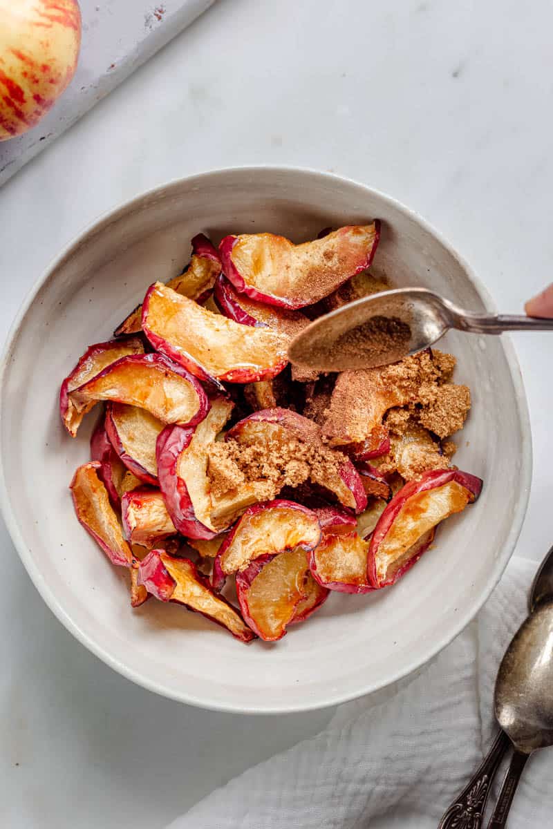 brown sugar and maple syrup added to the air fried baked apples in a bowl.