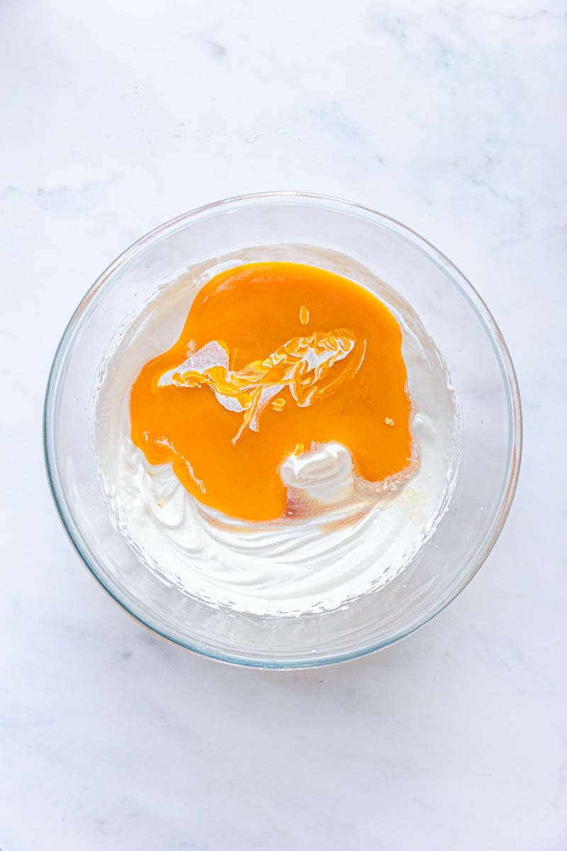 mango pulp and whipped cream in a bowl.