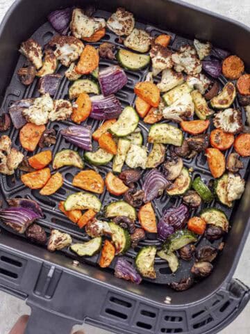 roasted vegetables in air fryer basket.
