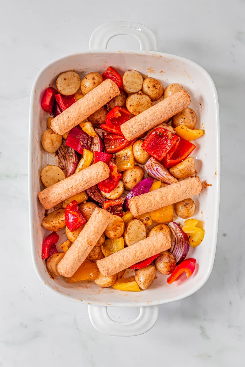 sausages are placed on top of marinated veggies.