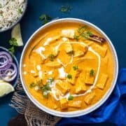 restaurant style paneer butter masala served with cumin rice and onion rings