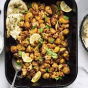 indian cauliflower traybake with potatoes served with naan bread.