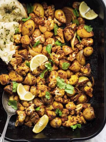 indian cauliflower traybake with potatoes served with naan bread.
