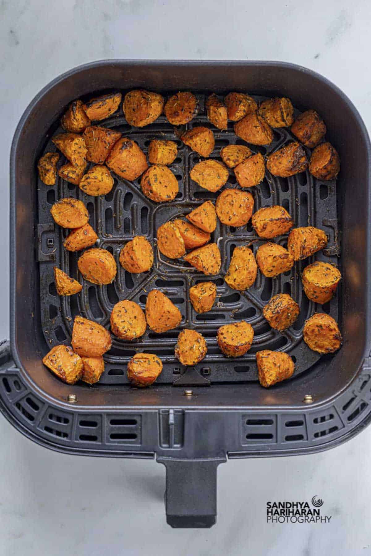 roasted carrots in air fryer basket.
