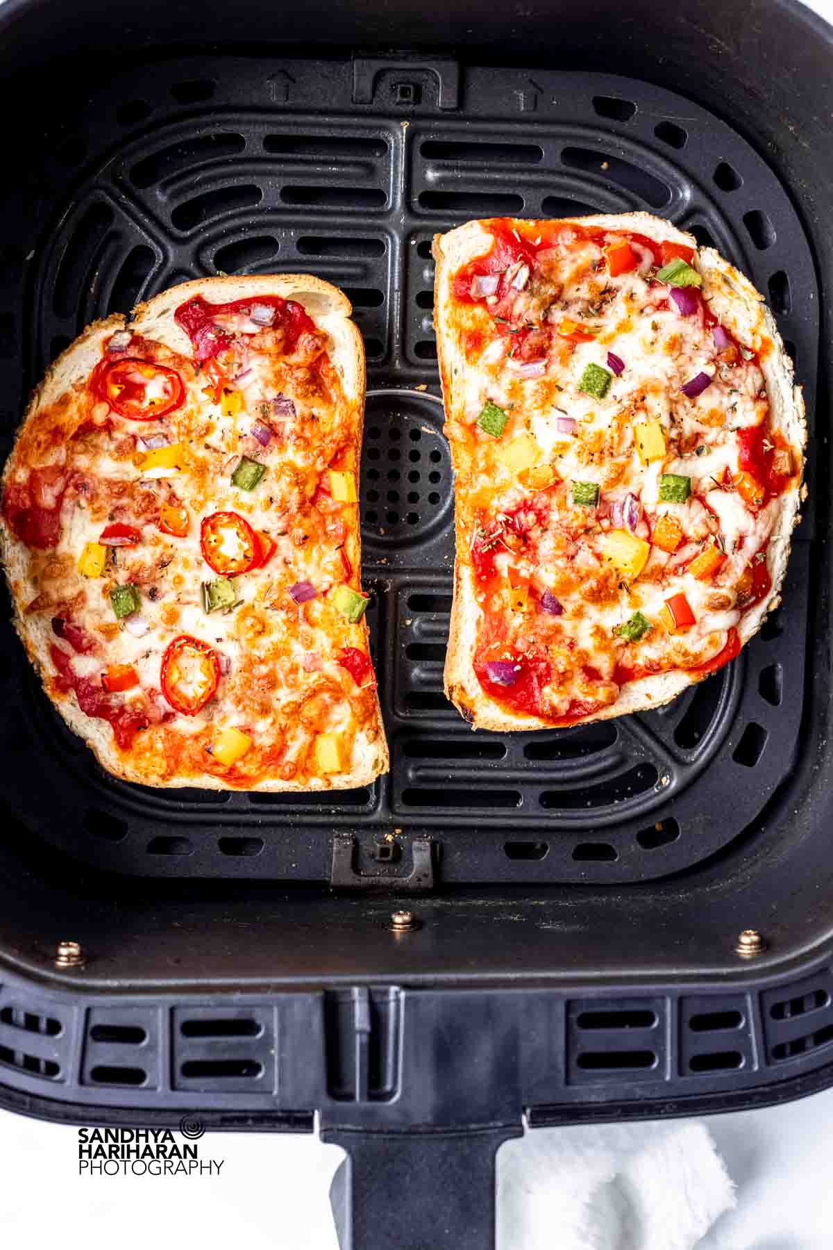air fryer bread pizza in the air fryer basket.