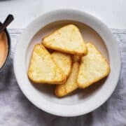 hash browns in a bowl served with sauce.