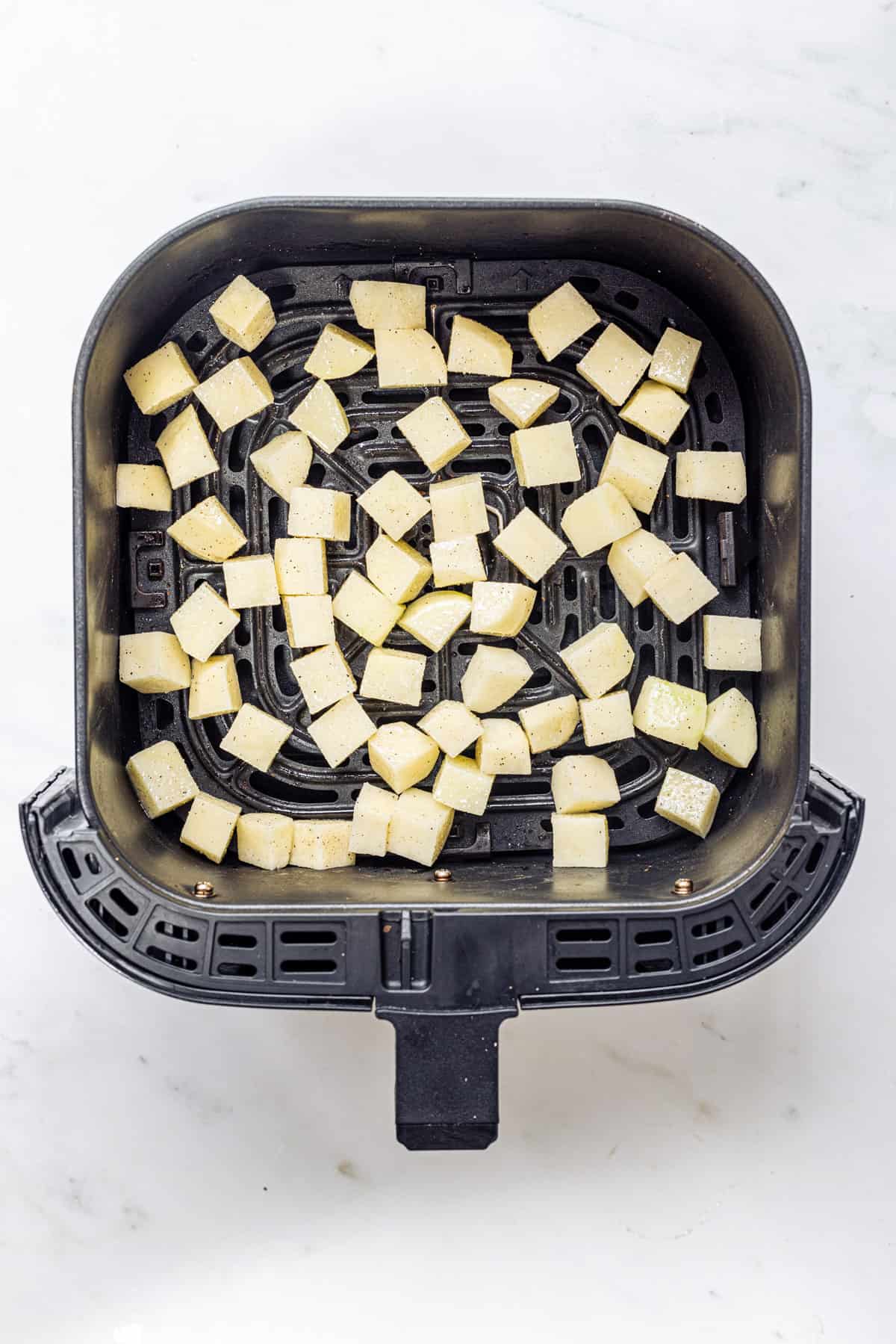 transfer the seasoned potatoes to air fryer basket for making parmentier potatoes.