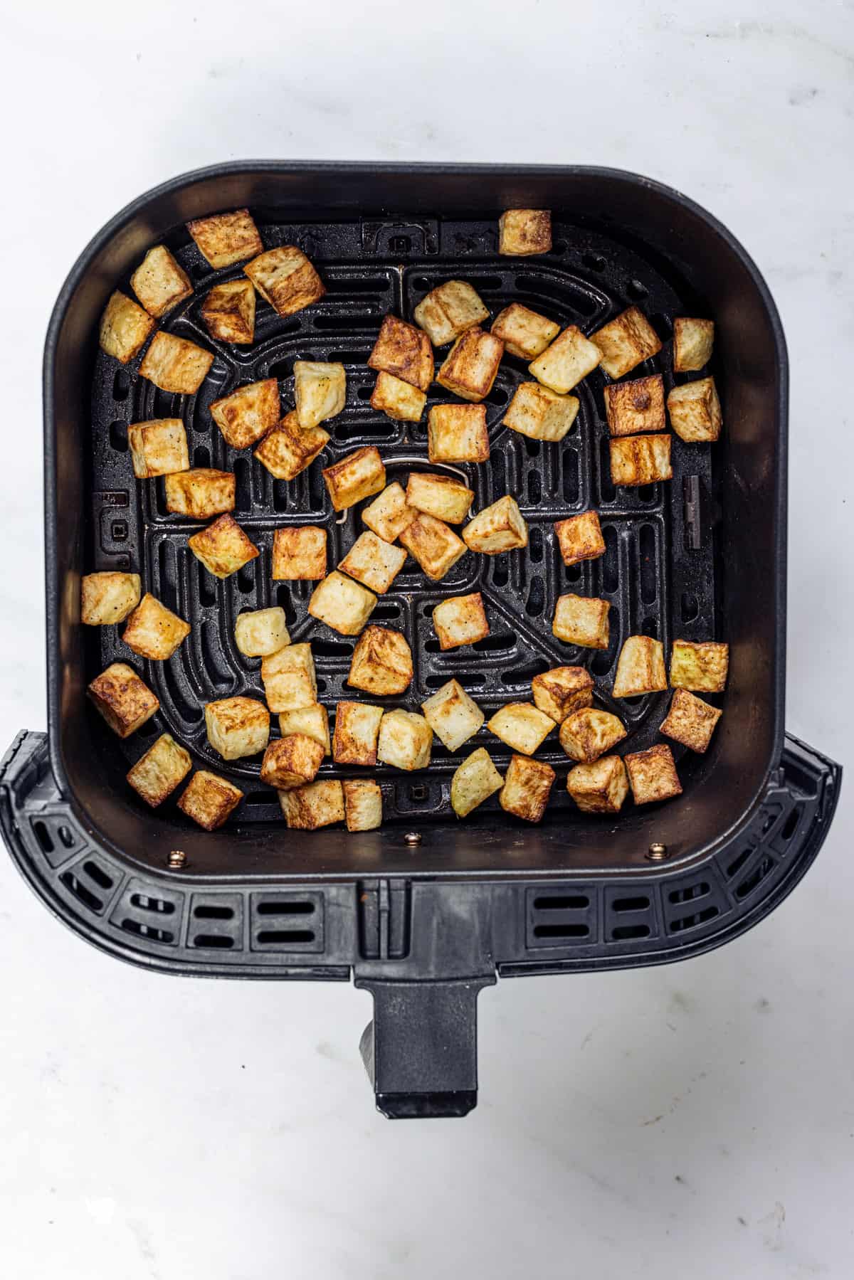 crispy parmentier potatoes in the air fryer basket.