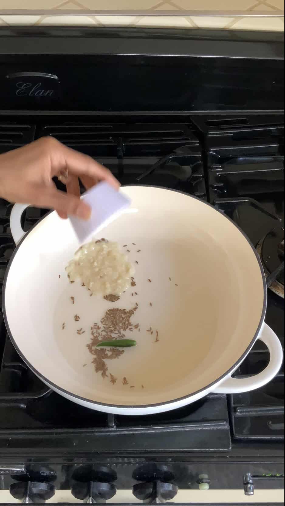 adding ginger garlic paste to the pan for making jalfrezi sauce.