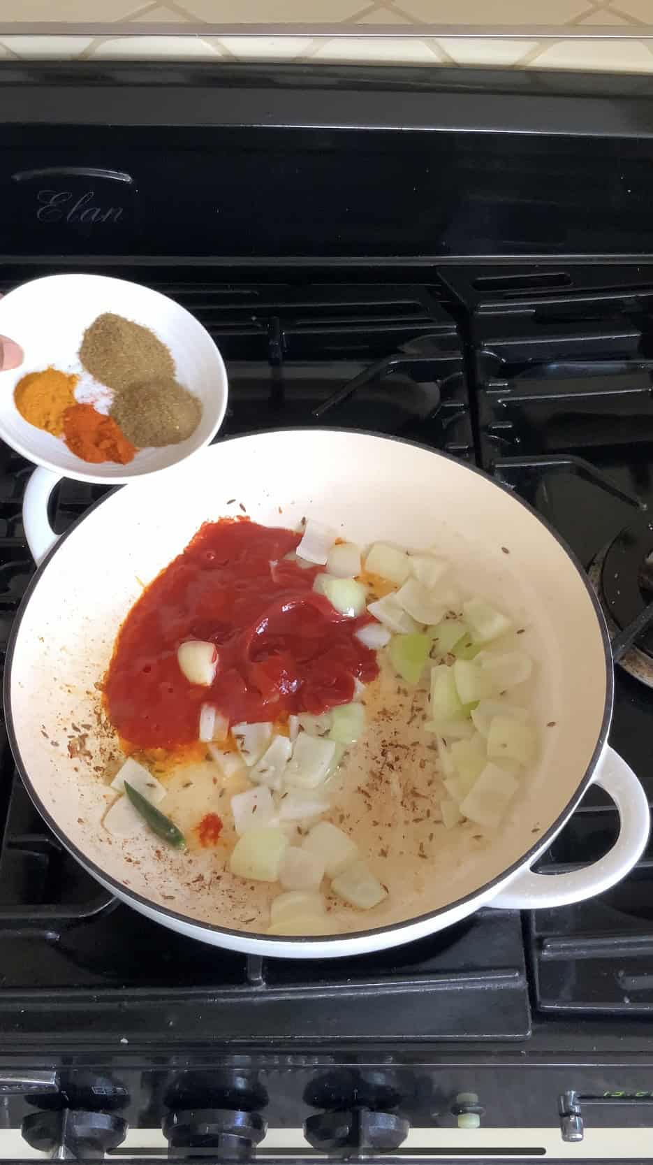 adding spices to the pan for jalfrezi sauce.