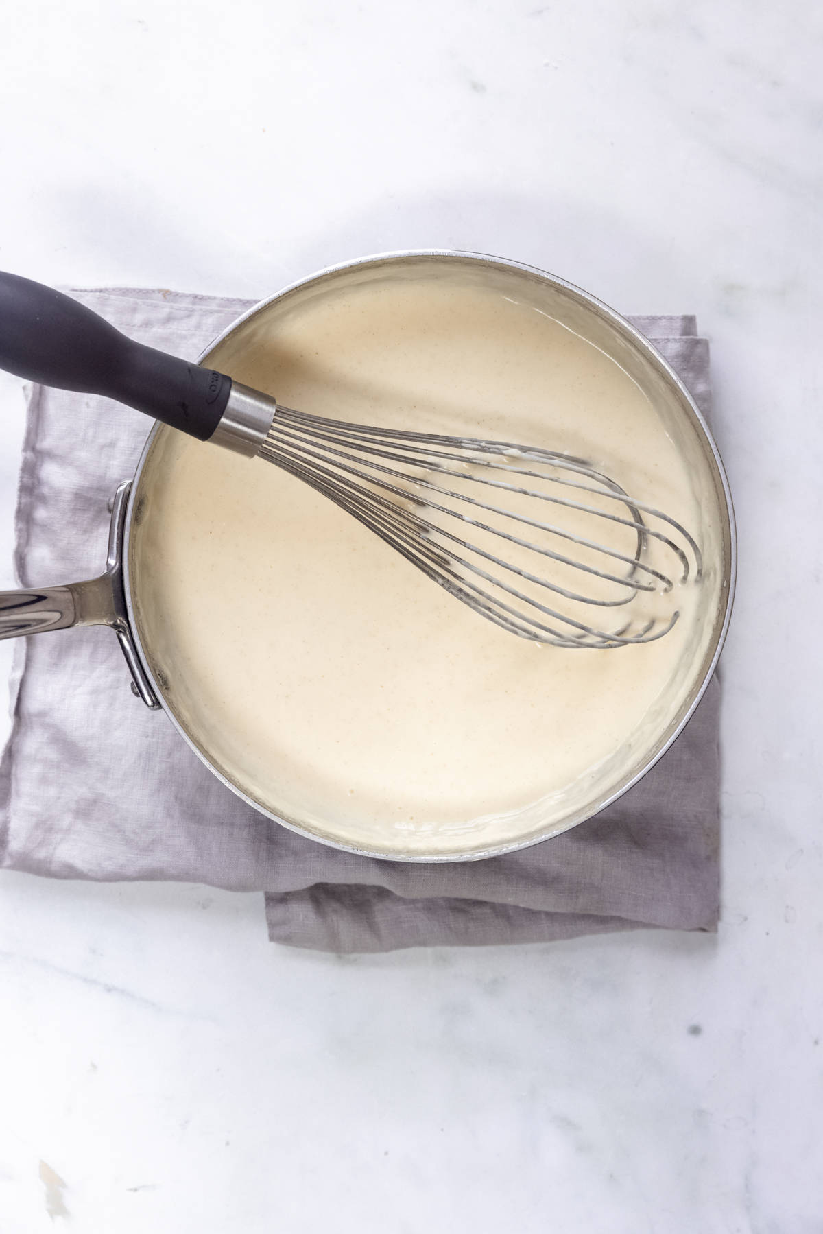 creamy white sauce in a saucepan for making air fryer cauliflower cauliflower cheese.