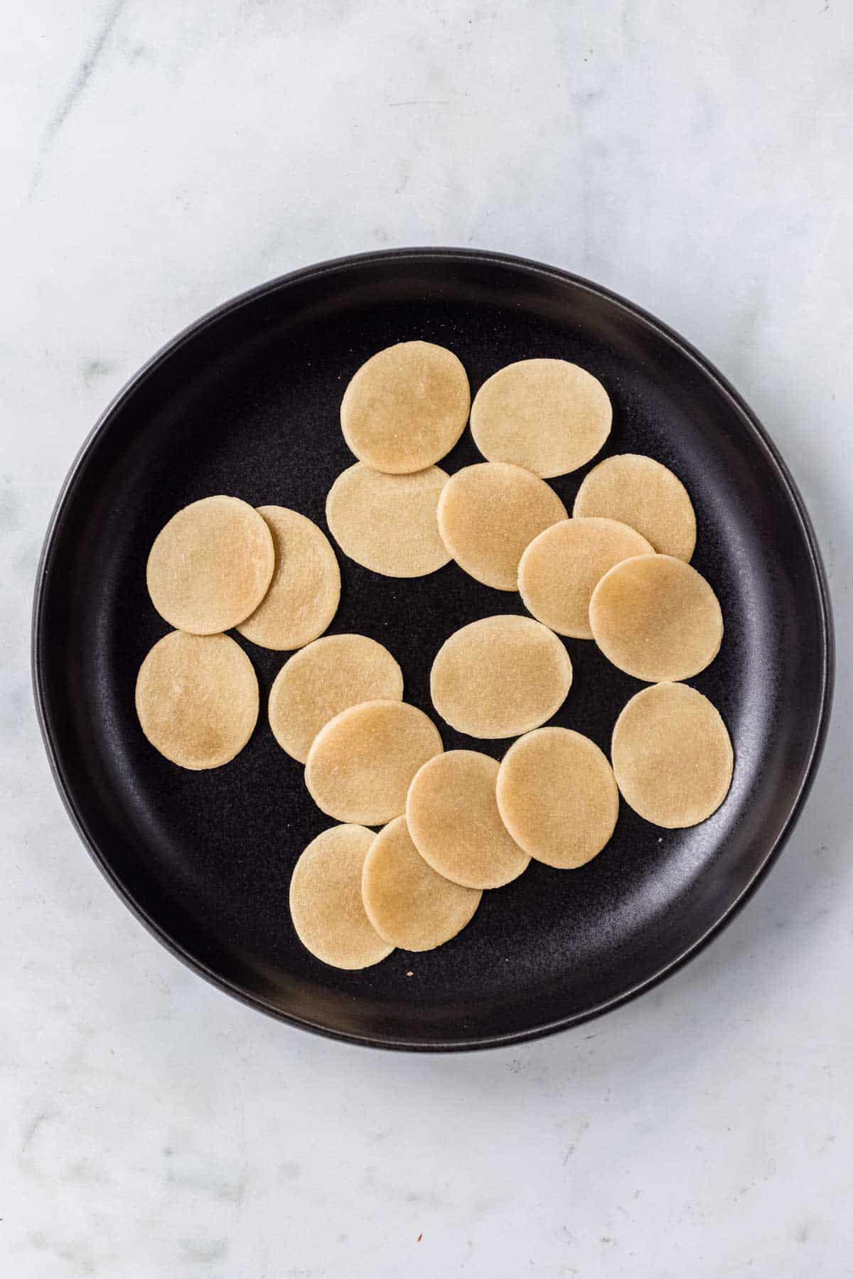 pani puri pellets in a black plate.