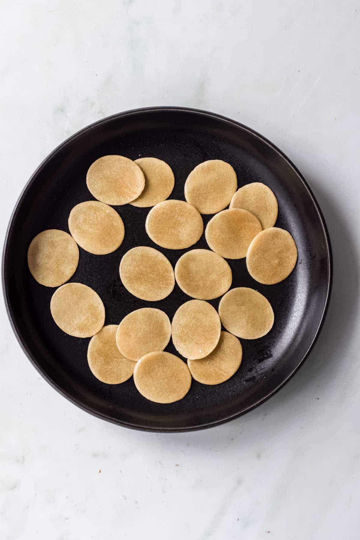 Place pani puri pellets on a plate and brush with oil.