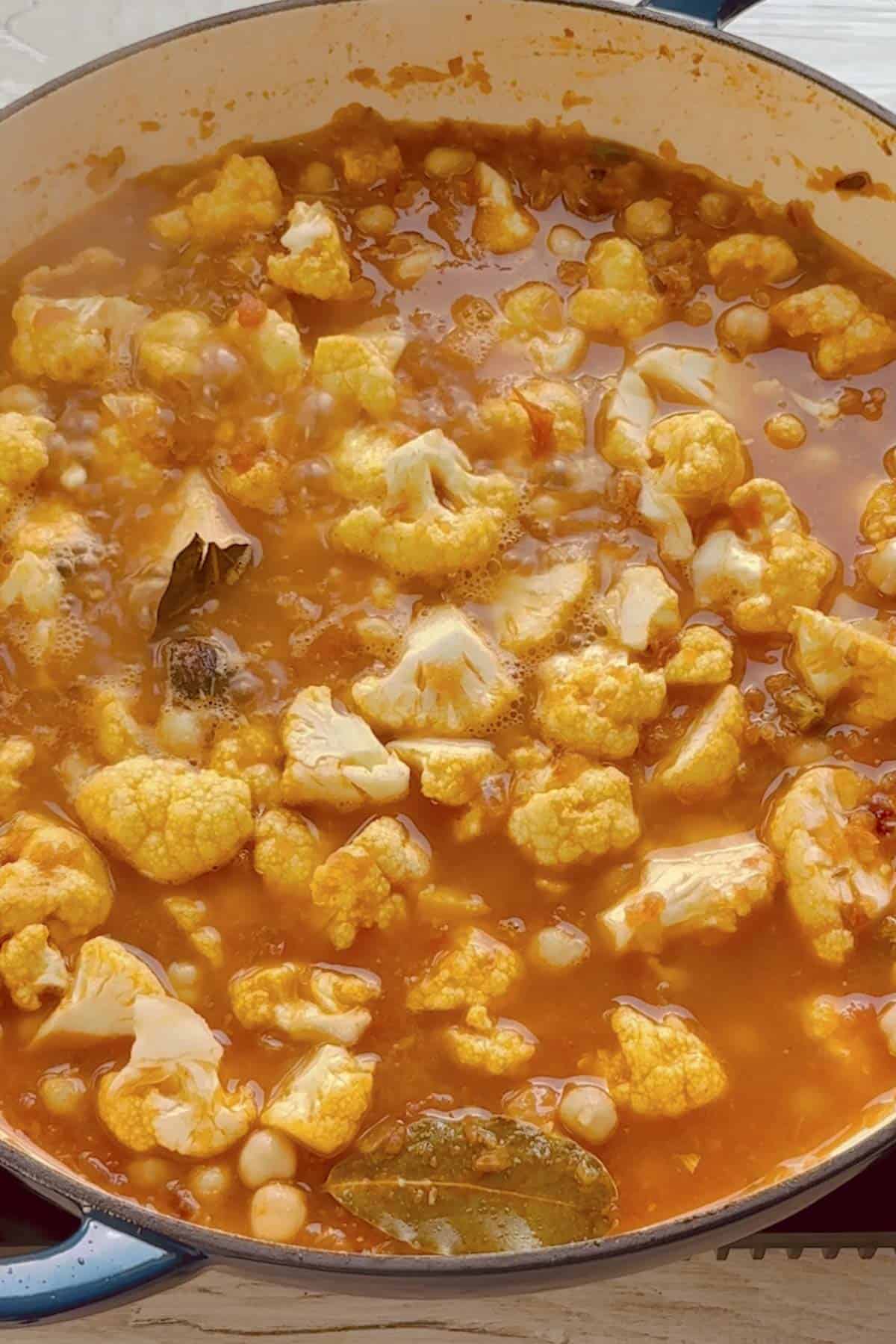 add cauliflower, chickpeas and water to make the curry.