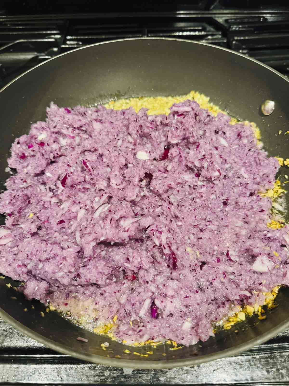 chopped onions on top of fried ginger garlic in the pan.