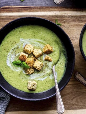 two bowls of roasted courgette soup with croutons