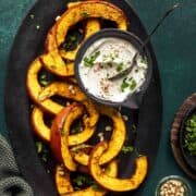 air fryer pumpkin slices on a oval black tray.