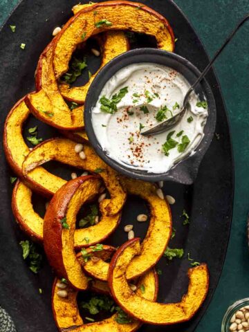 air fryer pumpkin slices on a oval black tray.