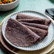 few ragi rotis on a white plate.
