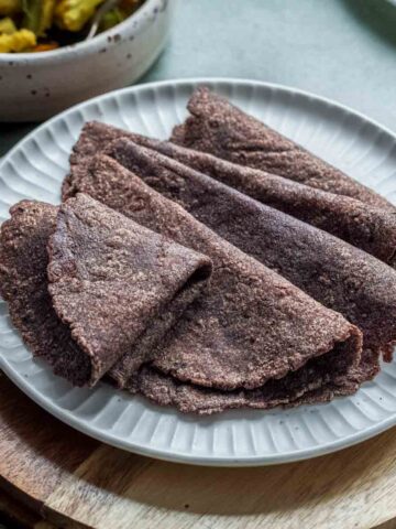 few ragi rotis on a white plate.