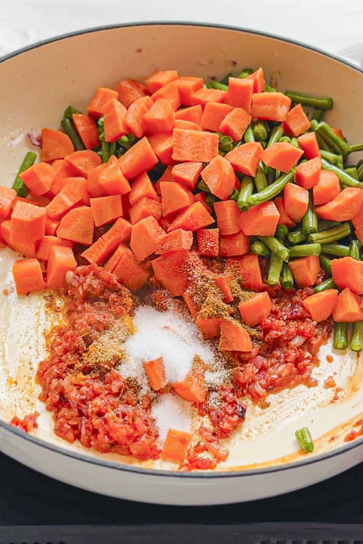 carrots, french beans and spices in a white pan.