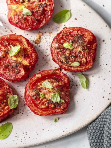 air fryer roasted tomatoes in a oval serving plate.