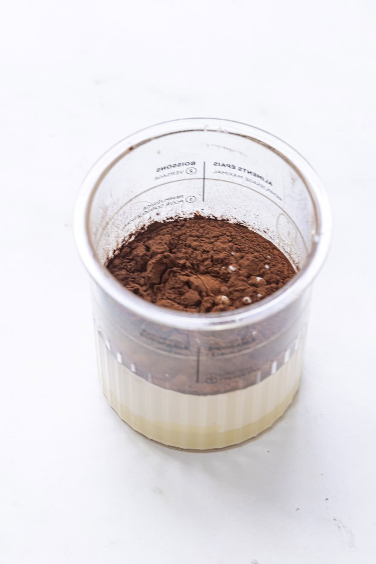 All ingredients for chocolate ice cream added to the ninja creami pint tub.