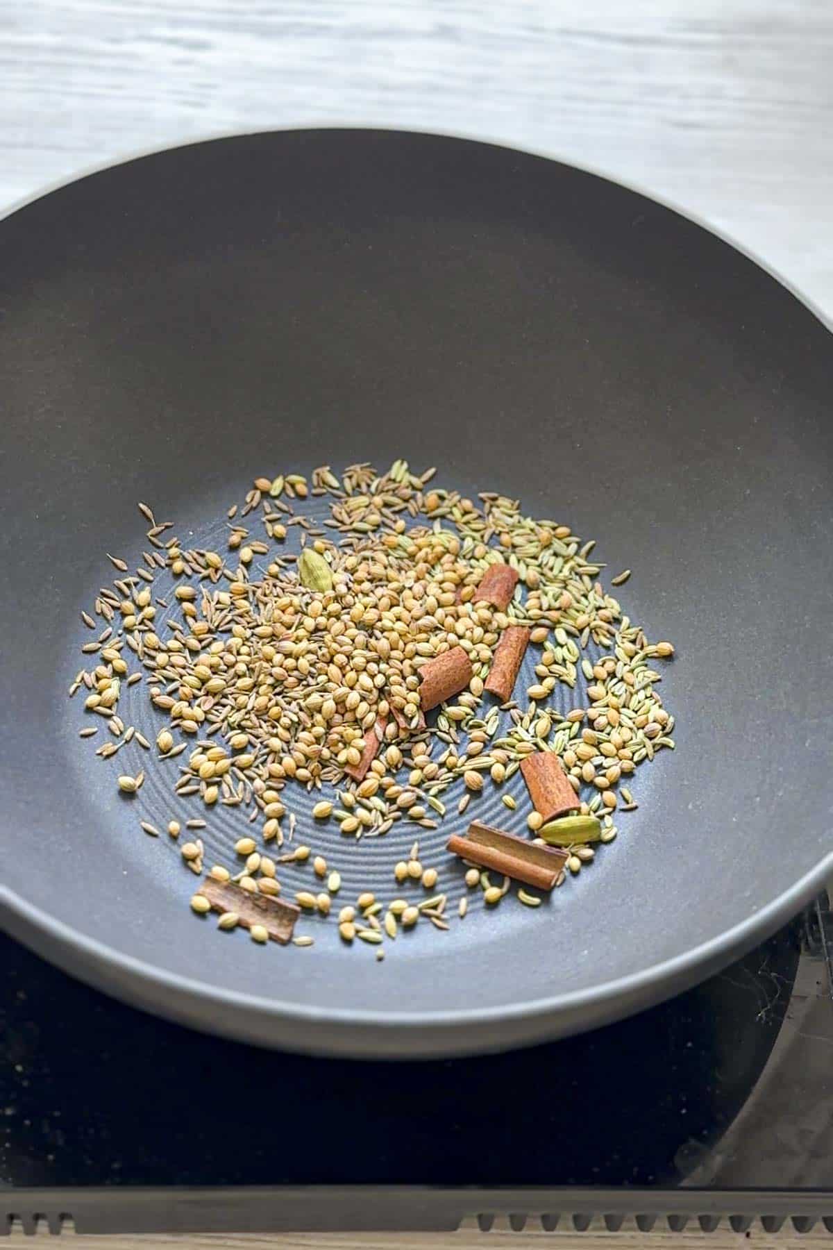 whole spices in a wok to make balti spice mix.