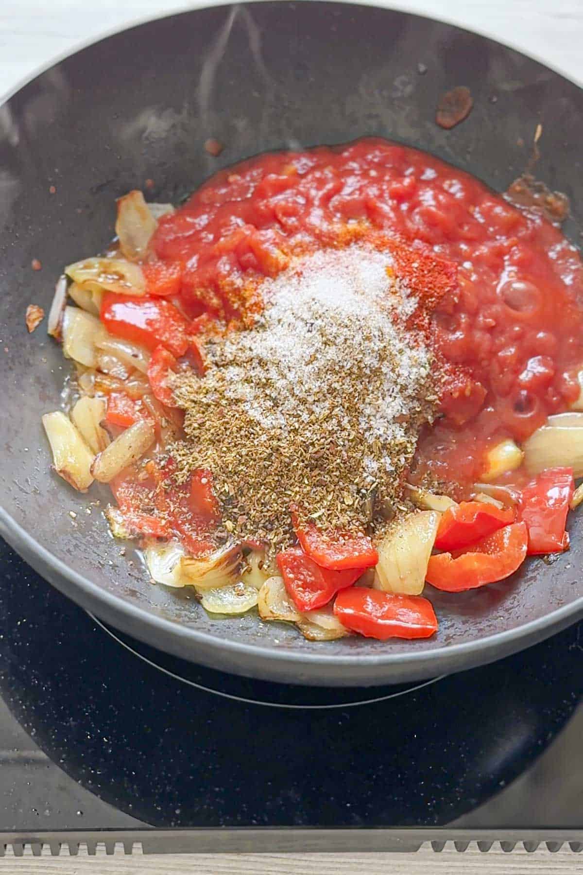 add the tomatoes, spices, salt and sugar to the wok.