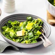 spring greens served with butter in a grey bowl.